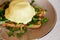 Close up of vegan alternative eggs benedict dish with wholegrain bread, creamy plant-based hollandaise sauce, tofu