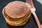 Close-up of vegan banana pancakes stack on black plate with copper fork