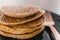 Close-up of vegan banana pancakes stack on black plate with copper fork