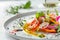 Close-up of vegetable salad with olive oil pouring.