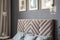 Close-up of a velvet headrest, posters on the wall, pillows and
