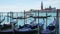 Close up of Venetian gondolas docked on the Grand canal under sunny sky