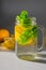 A close-up vertical contrast photo of a mug filled with water, sliced â€‹â€‹lemon and mint leaves