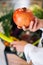 Close-up vertical cropped shot of unrecognizable customer female hands holding pomegranate at grocery store standing