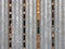 Close up of vertical galvanized steel fence with wooden pallets in outdoor storage visible between the gaps