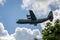 Close up of very low flying Hercules aircraft skimming over trees near Frome, Somerset, UK