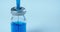 Close up video of ampoule with blue vaccine medication and syringe filling up from glass vial. Pharmaceutical production