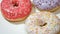 Close up video of assorted donuts with colorful sprinkles on white plate