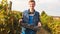 Close up video of a happy young farmer worker man holding a basket of ripe grapes in his hands going through the rows of