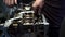 Close up video of unrecognizable mechanic assembles Car engine