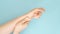 Close up video, unrecognizable woman massaging hand suffering from joint pain on a blue background. lady touching wrist