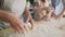 Close up video of women sprinkling flour and kneading dough.