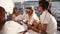 Close up view of 4 friends or couples spend a weekend on a yacht. Event on the yacht. Merry company in white clothes are