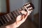 Close up view at acoustic guitar fretboard with female hand striking a chord