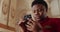 Close up view of african american man in red suit using his smartphone. Young male person looking and touching phone