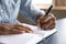 Close up view of african left-handed businessman writing in notebook