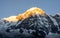 Close-up view of Annapurna South montain peak during sunrise golden hour against clear blue sky, Nepal