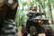 Close up view of another transport. Young couple riding a quad bike in the forest