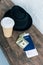 close up view of arranged passport, cash, coffee to go and hat