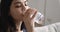 Close up view asian woman drinks glass of water