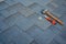 Close up view on asphalt bitumen shingles on a roof with hammer,nails and stationery knife background.