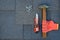 Close up view on asphalt shingles on a roof with hammer,nails and knife. Use of gloves in construction.