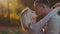 Close up view of attractive young blonde girl passionately kissing her handsome boyfriend in a warm autumn sunshine