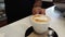 Close-up view of a barista demonstrating the art of pouring and preparing a cup of cappuccino coffee