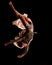 Close-up view of beautiful woman jumps at dark time and performs trick upside down