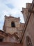 Close up view of the bell tower and gargoyles of the Santa Maria Cathedral in La Ciutadella in Menorca against a blue cloudy sky