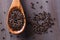 Close up view of black barley grains on wooden spoon