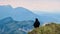 Close up view of black ravens on top of Feistritzer Spitze (Hochpetzen) with scenic view of majestic mountain peaks Karawanks