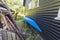 Close up view of blue kayak parked near dark house wall.