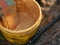 Close up view on bucket with golden paint. Multicolor bath puff in bucket. Vintage background. Plastic bucket with paint