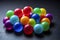 Close up view of bunch vibrant multi coloured glossy balls on a dark surface.