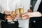 Close-up view of business team of multinational employees holding clinking glasses of champagne