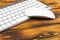 Close up view of a business workplace with wireless computer keyboard, keys and mouse on old dark burned wooden table background.