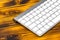 Close up view of a business workplace with wireless computer keyboard, keys on old dark burned wooden table background.