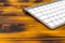 Close up view of a business workplace with wireless computer keyboard, keys on old dark burned wooden table background. Office