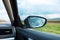 Close-up view of car side mirror from inside of auto vehicle.