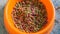 Close up view of cat diet food in a orange bowl