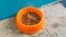 Close up view of cat diet food in a orange bowl and half-cut plastic bottle for drink water