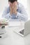 Close-up view of Caucasian businessman with heads in hands at his desk