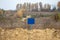 Close-up view of a caution banner, mock-up of a blue plate on an iron mesh fence with barbed wire. Closed area designation blank.