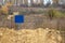 Close-up view of a caution banner, mock-up of a blue plate on an iron mesh fence with barbed wire. Closed area designation blank.