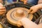 A close up view on ceramic production process on potter`s wheel with children. Clay crafts with kids concept