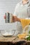 Close-up view of chef sifts flour into glass bowl for cooking pasta alla carbonara. Backstage of preparing traditional italian