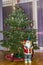 Close up view of Christmas fir tree with colorful Christmas decorations, Santa Claus figure and Nutcracker. Postcard.