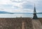 Close up view of a church roof with steeple and a lake view behind