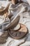 A close-up view of clay plates and a paint brush on a wooden table and dried flowers on a background. Crafted tableware